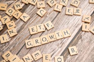 Aufnahme zahlreicher Scrabble-Steine die auf einem Tisch liegen und zusammen die Worte „ETF“ und „GROWTH“ formen – Symbolbild zu ETF-Auswahlmöglichkeiten.