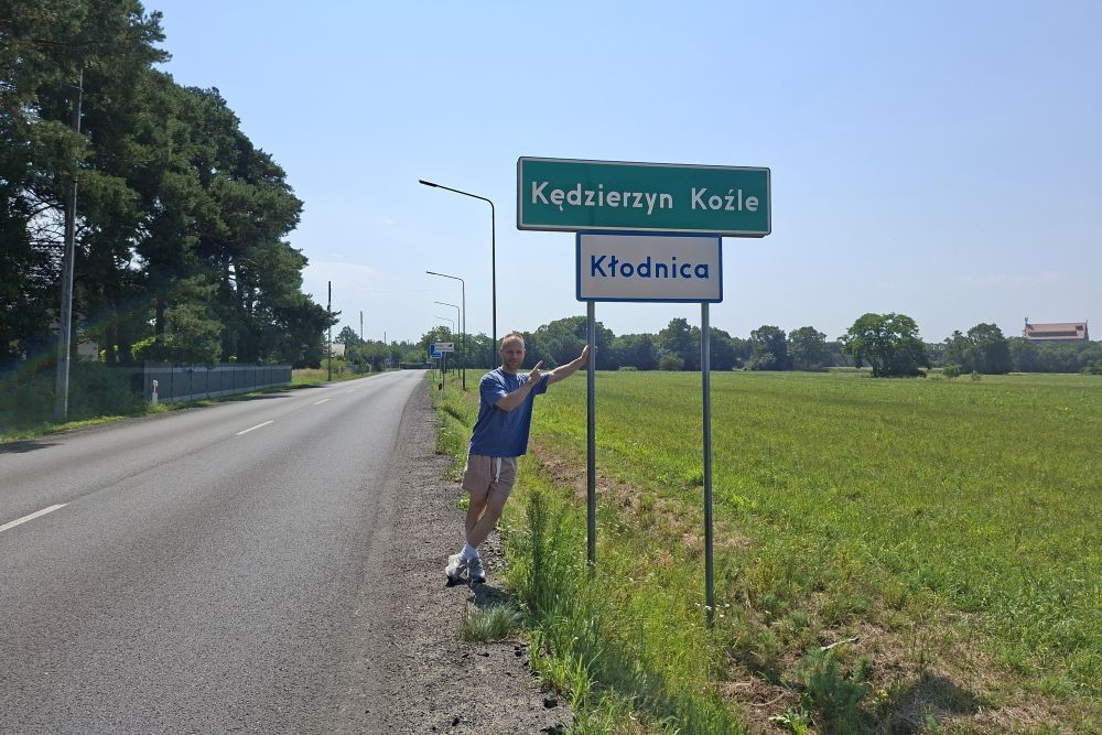 Der Blog-Autor neben dem Ortsschild der polnischen Stadt Kędzierzyn-Koźle an einer Landstraße.