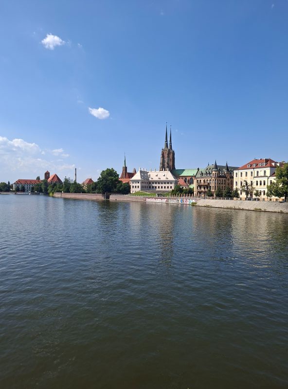 Panoramablick über das Wasser der Oder auf die historische Skyline von Breslau mit ihren Kirchtürmen.