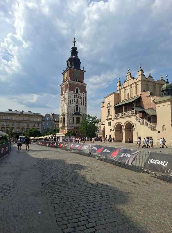Historischer Rathausturm und die Tuchhallen am Hauptmarkt in Krakau unter leicht bewölktem Himmel.