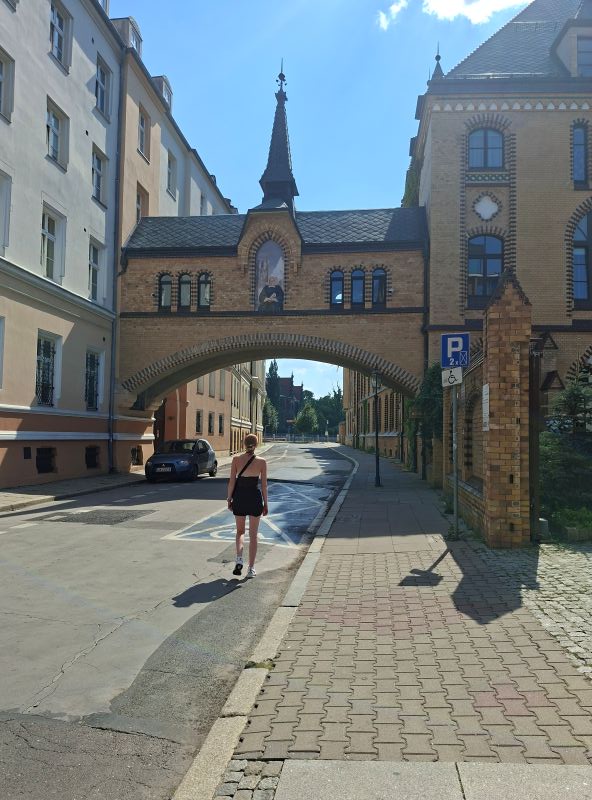 Blick durch eine historische Tordurchfahrt in eine gepflasterte Straße in Breslau.