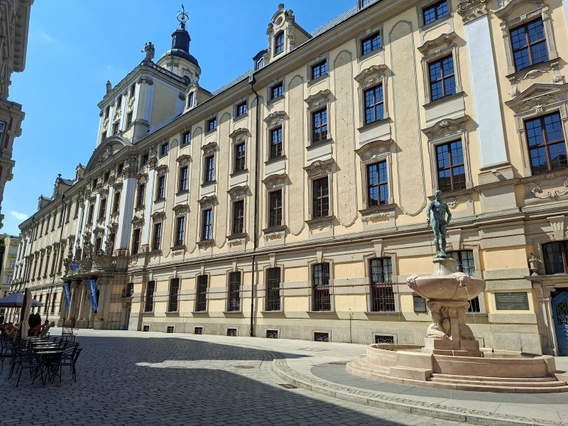 Barocke Fassade des Hauptgebäudes der Universität Breslau mit dem Fechtbrunnen im Vordergrund.